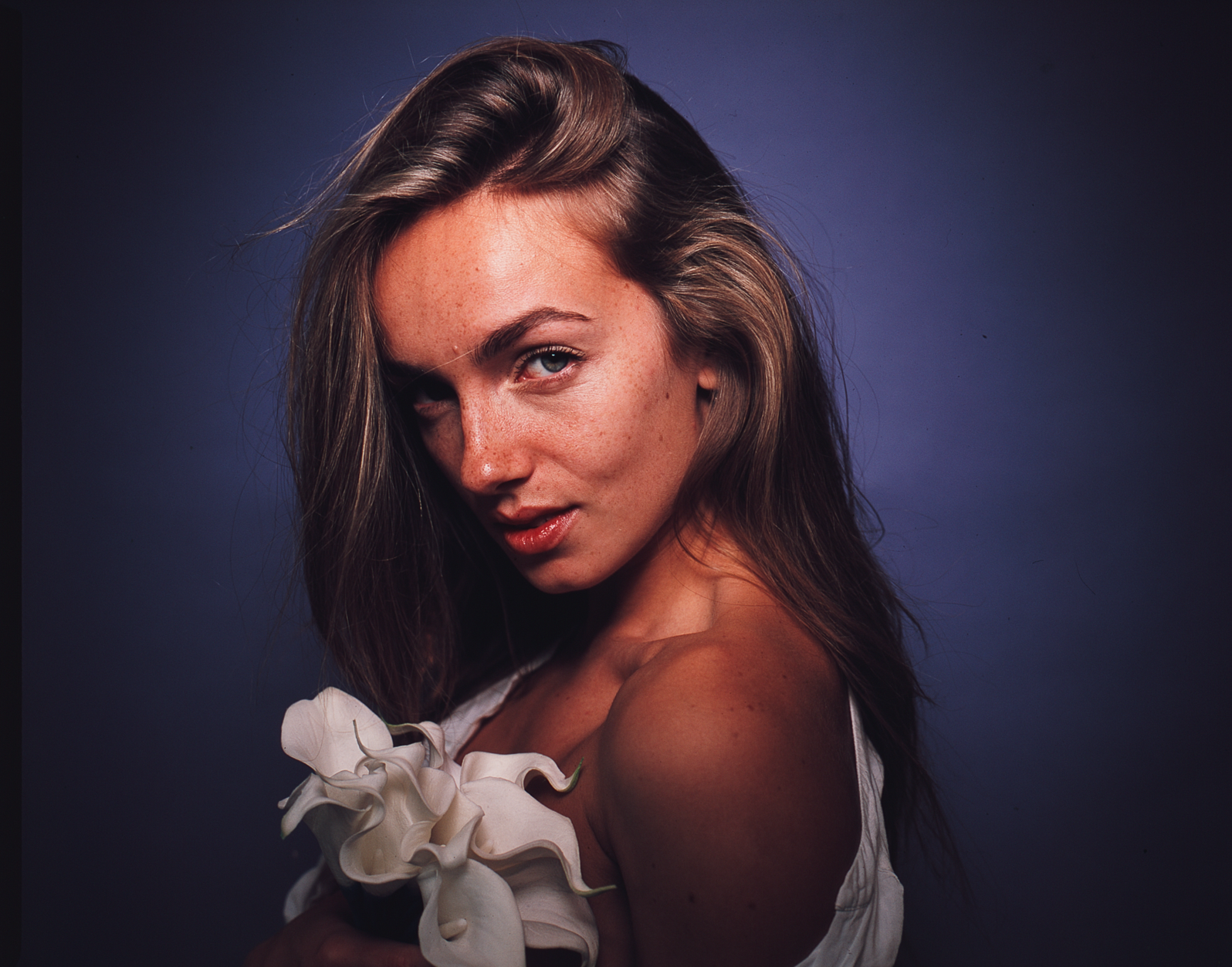 Moody portrait with dramatic lighting and white floral details